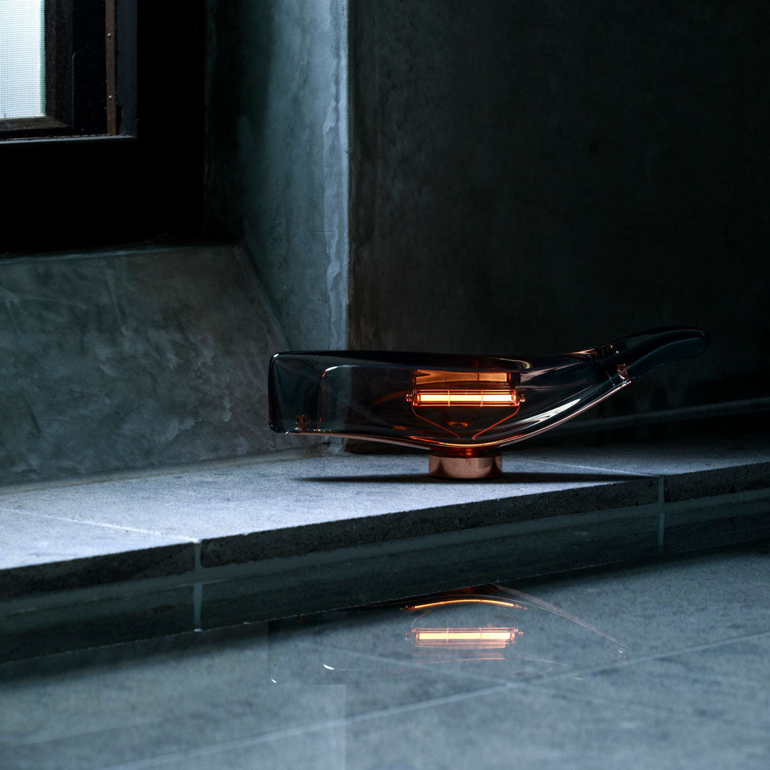 Stylish transparent gray design with warm amber accents, set on a sleek gray stone surface. Modern, minimalist aesthetic.