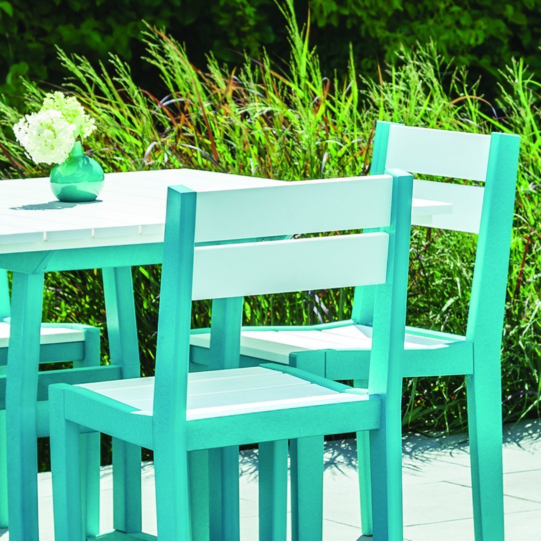 Turquoise outdoor furniture set with a minimalistic design and white accents, surrounded by lush greenery.