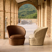 Brown wicker chair with a brown cushion and a light beige wicker chair with a gray cushion, set in a sunny outdoor space.