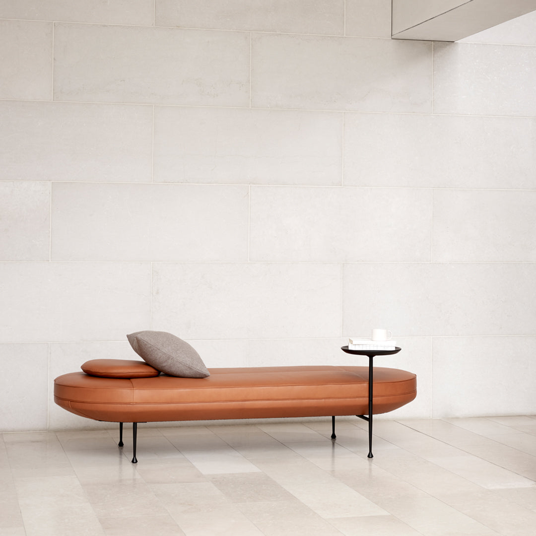 Modern brown wood sofa with a gray cushion, featuring clean lines and a minimalist design against a light backdrop.