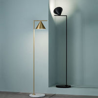 Modern floor lamps featuring a gold cone shade and a sleek black shade, both against a soft teal background.