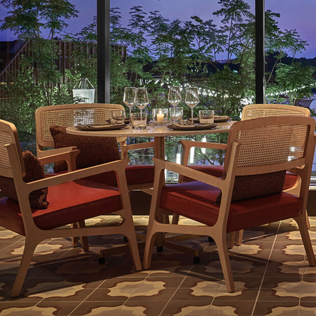 Modern dining set with wood and red upholstery, featuring a patterned brown and cream floor. Cozy, elegant ambiance.