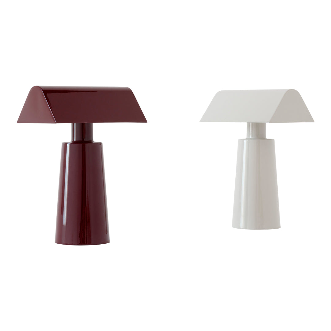 "Modern table lamps in deep burgundy and clean white with geometric shapes and glossy finishes."