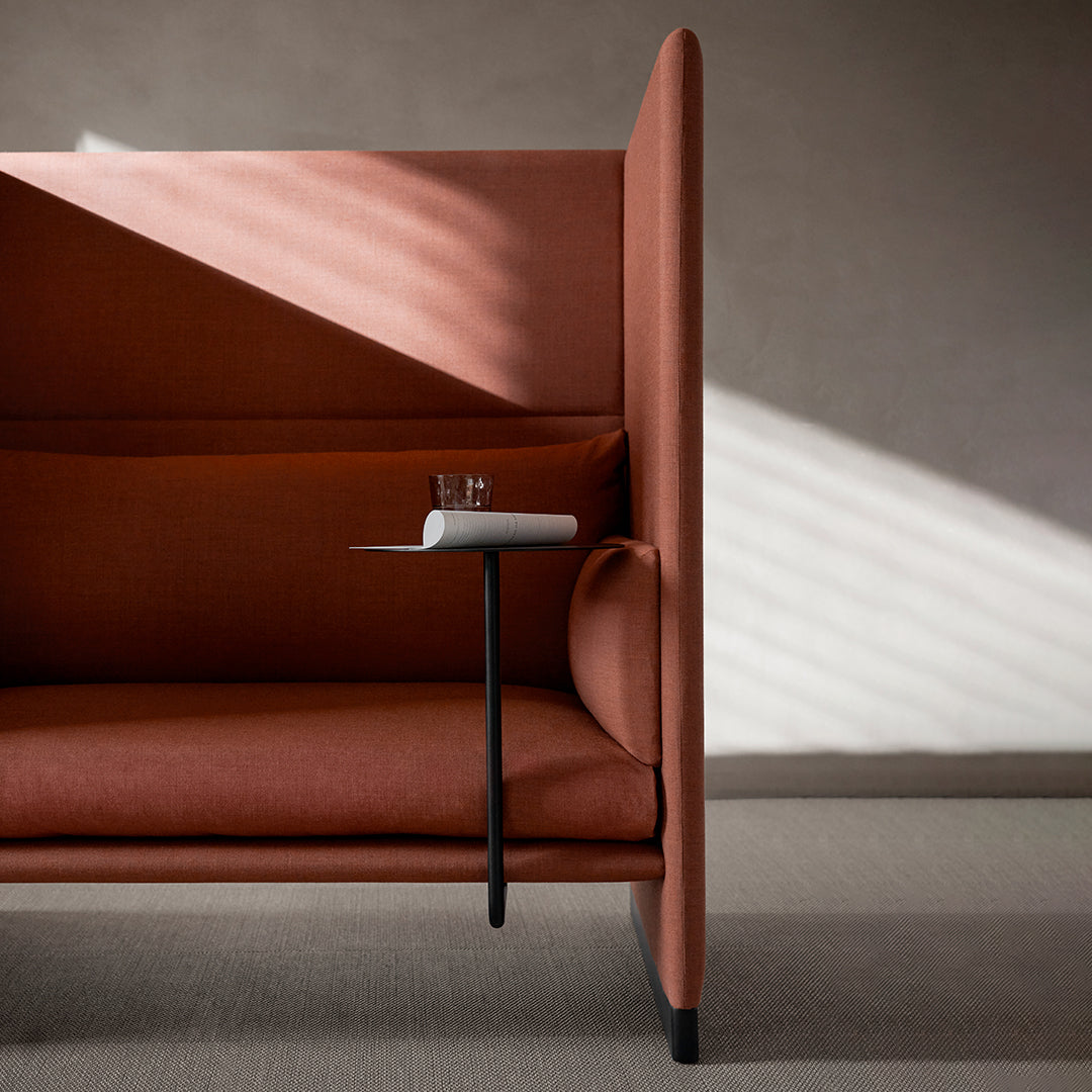 "Rustic terracotta sofa with smooth fabric and minimalist design, accentuated by soft shadows and light patterns."