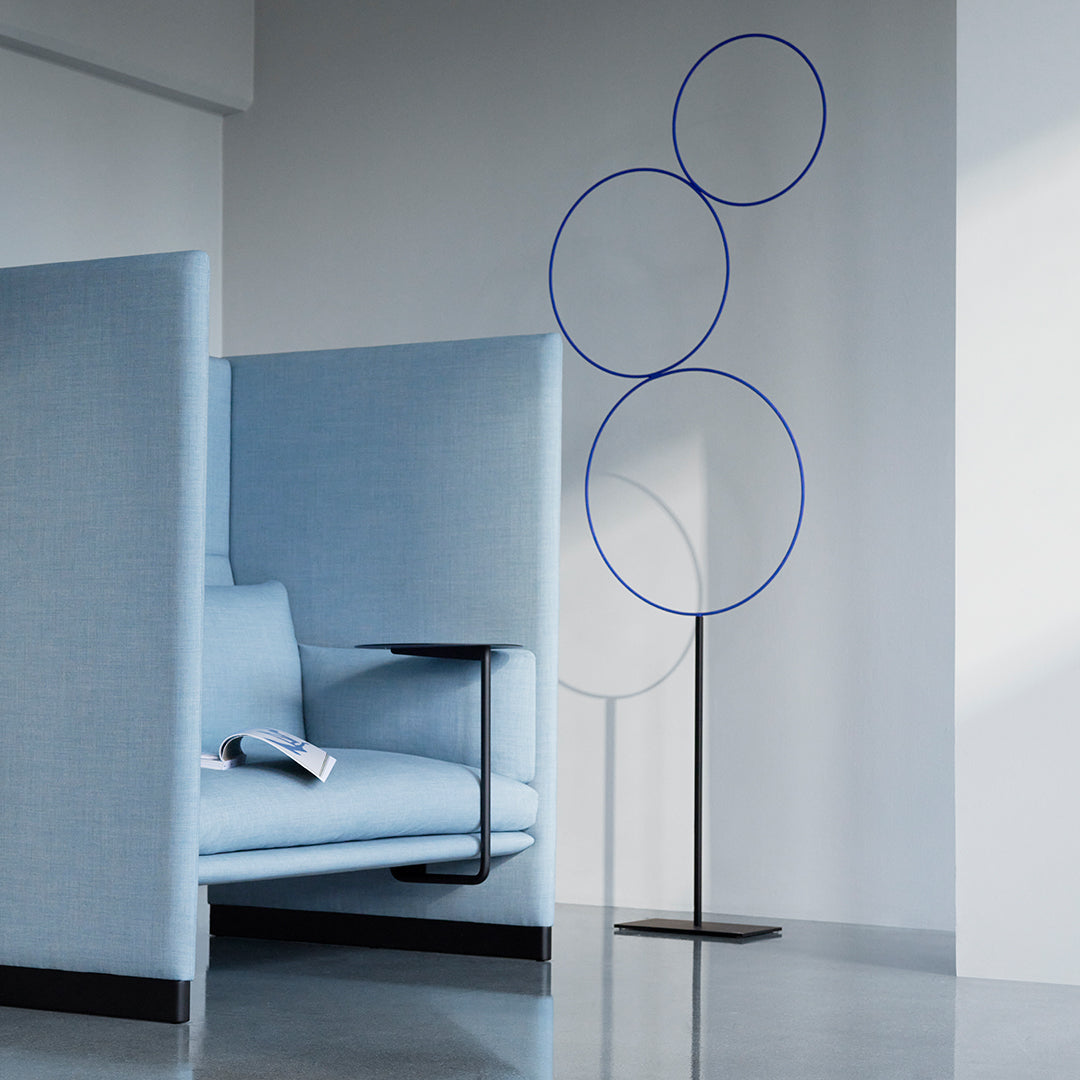 Light blue seating with minimalist design and three circular blue accents on a sleek stand. Modern and stylish.