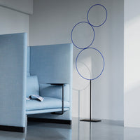 Light blue seating with minimalist design and three circular blue accents on a sleek stand. Modern and stylish.