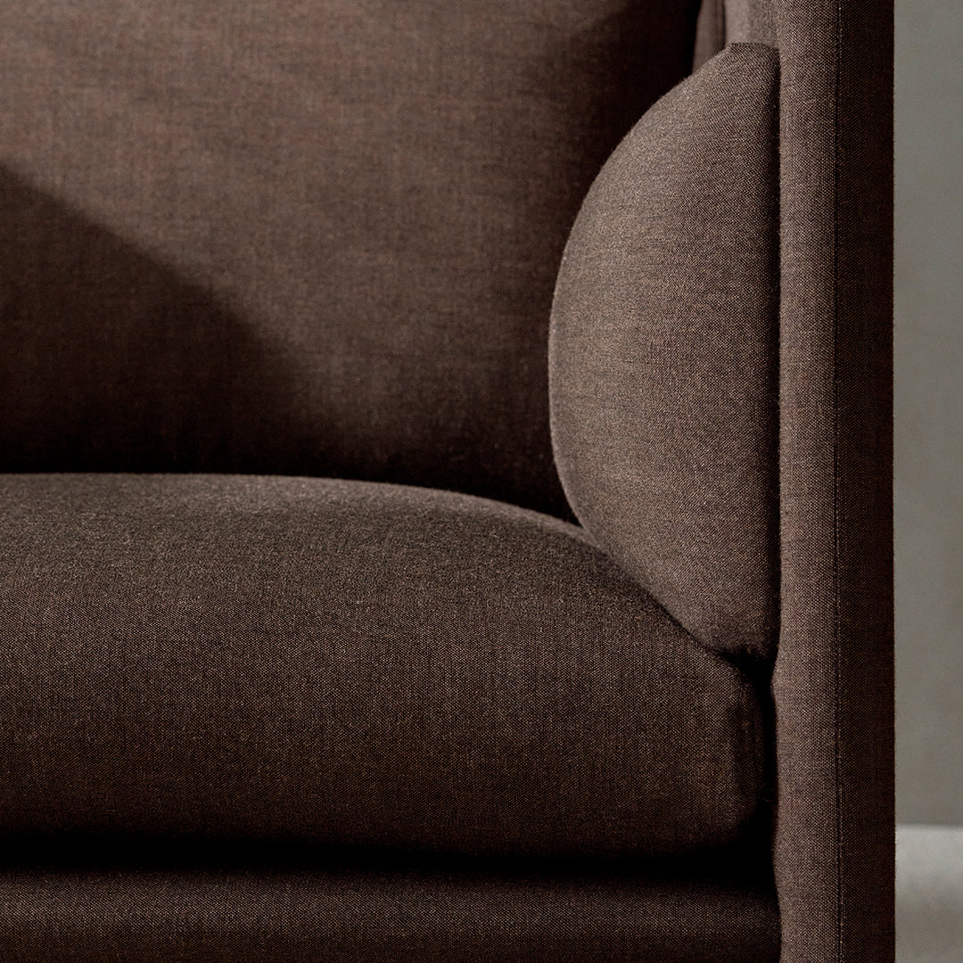 Brown textured fabric sofa with a smooth finish and curved armrest detail. Ideal for modern living spaces.