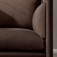 Brown textured fabric sofa with a smooth finish and curved armrest detail. Ideal for modern living spaces.