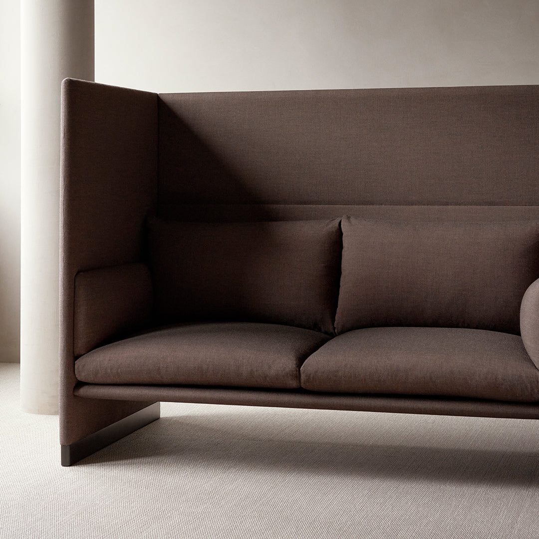 Stylish brown upholstered sofa with clean lines and minimalist design, featuring two plush pillows.