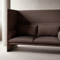 Stylish brown upholstered sofa with clean lines and minimalist design, featuring two plush pillows.