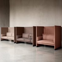 Modern three-seater sofa in soft taupe and muted terracotta tones, featuring clean lines and minimalistic design.