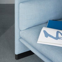 Light blue textured fabric sofa with sleek black legs, showcasing modern and minimalist design elements.