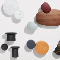 Colorful assortment of decorative tabletop objects featuring white, black, blue, orange, and rich wood tones with varied shapes.
