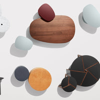 Colorful assortment of modern tables featuring wood, black, orange, and soft blue tones with various organic shapes.
