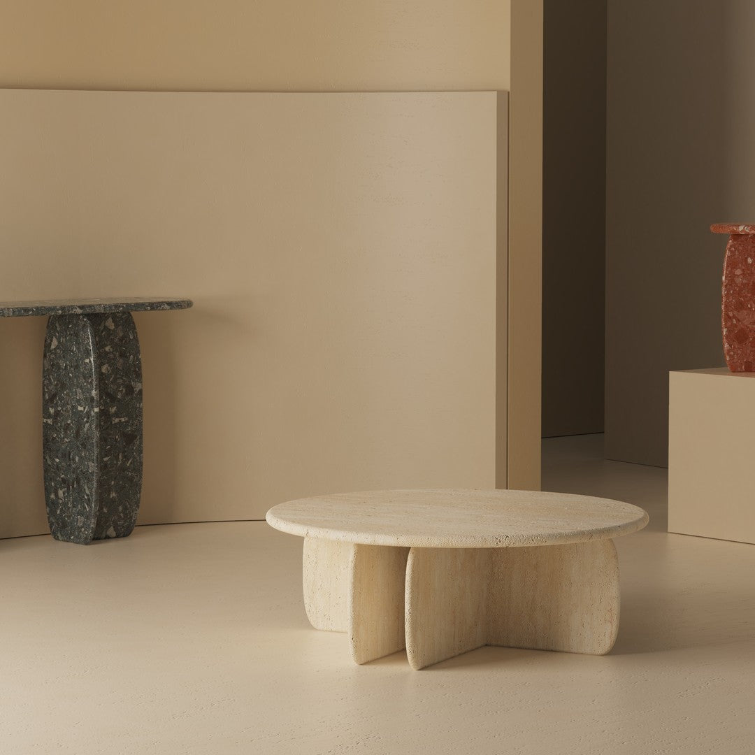 Cream round coffee table with textured finish, surrounded by minimalist beige and earthy-toned decor elements.