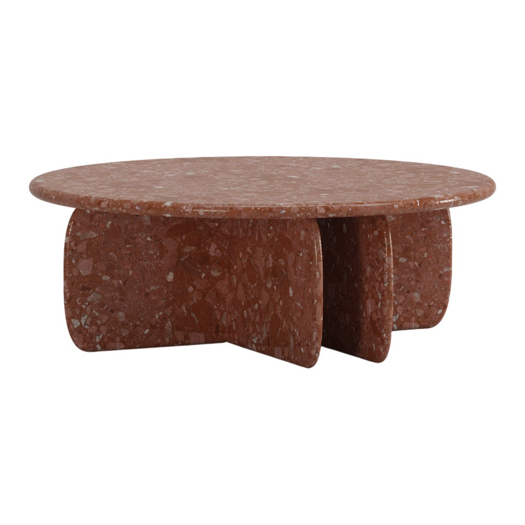 Round terracotta coffee table with a speckled texture and unique, bold shape. Perfect for modern home decor.
