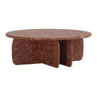 Round terracotta coffee table with a speckled texture and unique, bold shape. Perfect for modern home decor.
