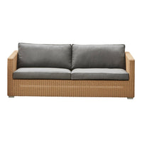 Gray cushions on a woven rattan sofa with a natural wood finish, adding a modern touch to outdoor decor.
