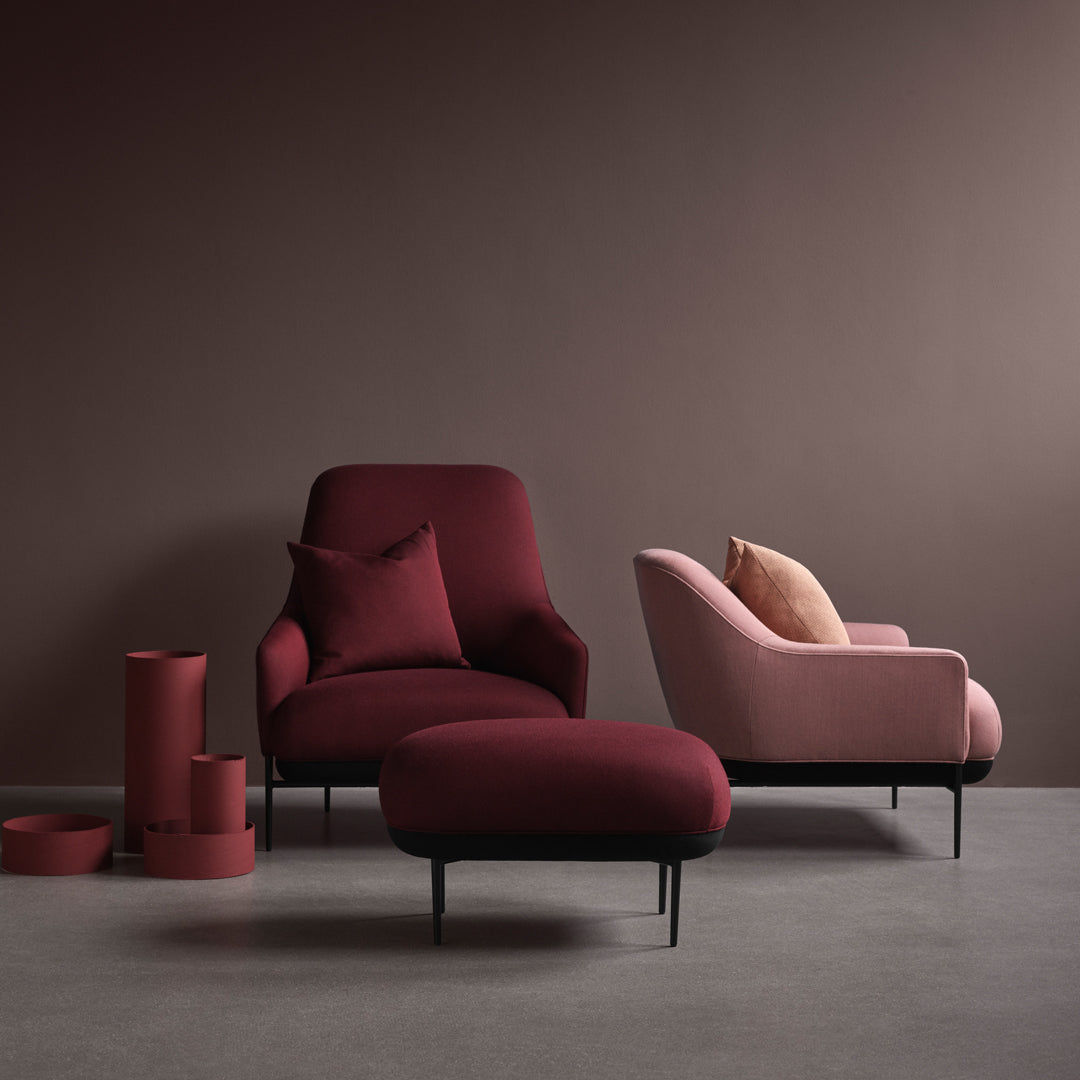 Modern furniture set with deep burgundy and soft pink hues, featuring rich textures and sleek lines against a neutral backdrop.