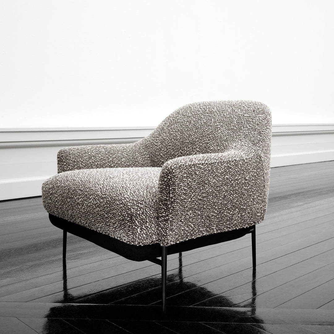 Textured gray and white patterned armchair with a sleek black metal frame, perfect for modern interiors.