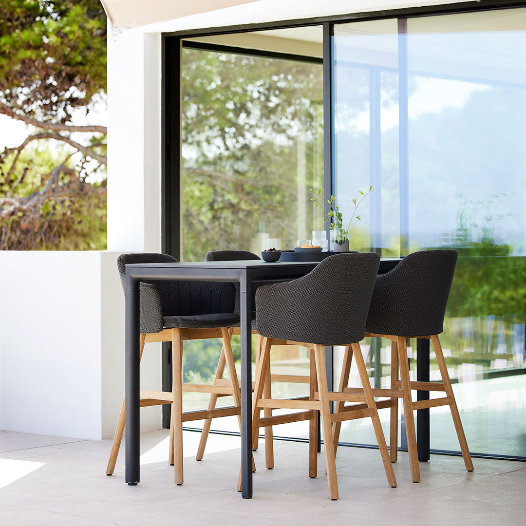 Modern outdoor bar set featuring black and natural wood tones, sleek lines, and minimalistic design. Perfect for patios.