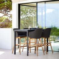 Modern outdoor bar set featuring black and natural wood tones, sleek lines, and minimalistic design. Perfect for patios.