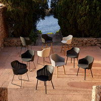 Set of modern chairs in black, gray, and white with striped patterns, arranged outdoors near a scenic view.