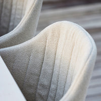 Soft beige chair with vertical ribbed pattern, textured fabric, ideal for modern interior decor.