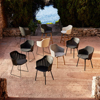 Variety of modern chairs in black, white, and gray with ribbed patterns, set against a scenic outdoor backdrop.
