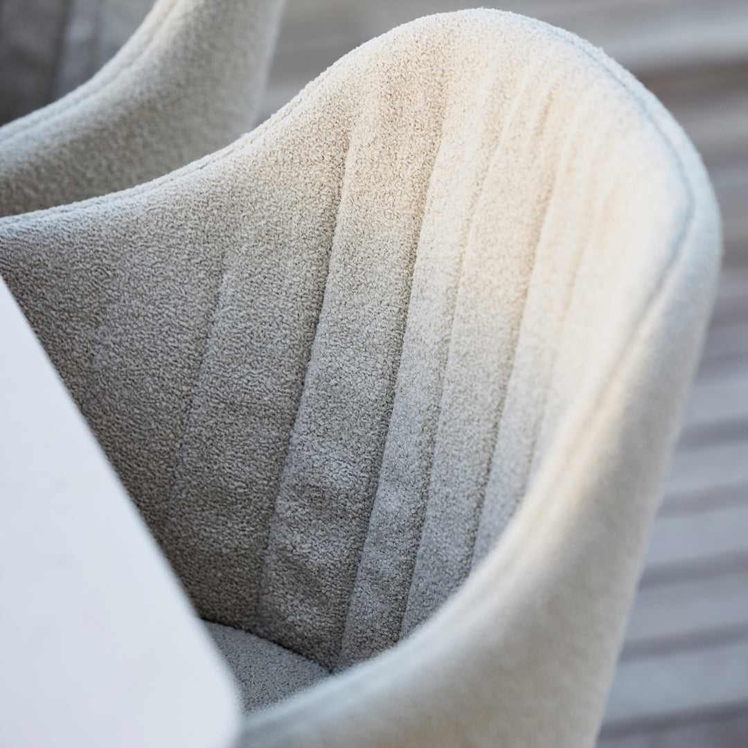 Light beige upholstered chair with vertical ribbed pattern, adding a cozy, textured look to any space.