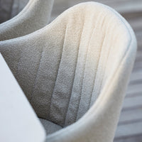 Light beige upholstered chair with vertical ribbed pattern, adding a cozy, textured look to any space.