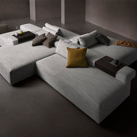 Modern gray sectional sofa with textured fabric, accented by mustard and neutral-toned throw pillows for added style.