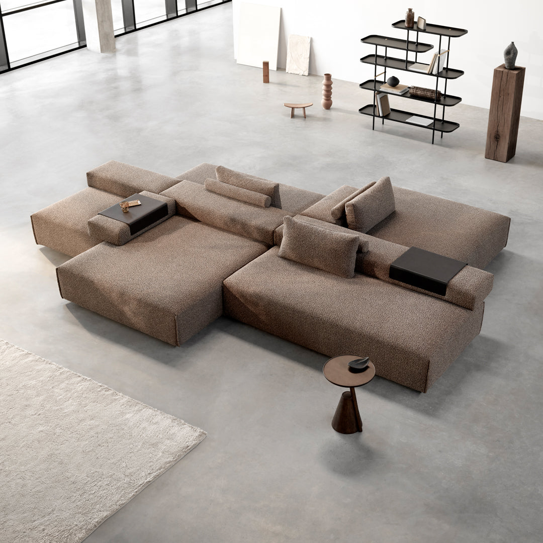 Modern sectional sofa in rich taupe fabric with clean lines and subtle texture, paired with minimalist decor elements.