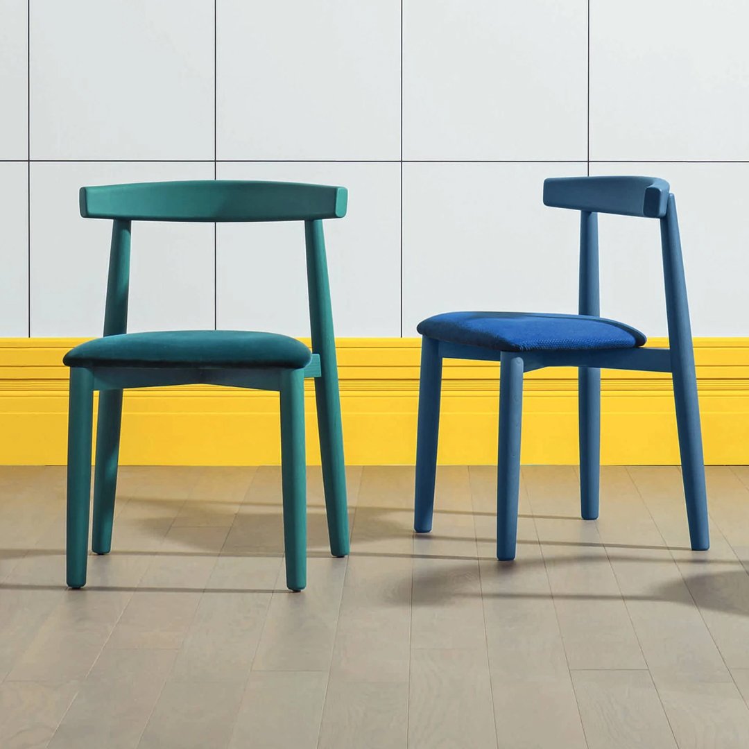 Two stylish chairs in deep teal and vibrant blue, featuring solid colors and a modern design against a bright yellow backdrop.