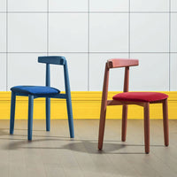 Two modern chairs in vibrant blue and red with simple, sleek designs against a bright yellow and white tiled backdrop.