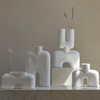 Set of modern white ceramic vases with unique shapes and textured patterns, ideal for stylish home decor.