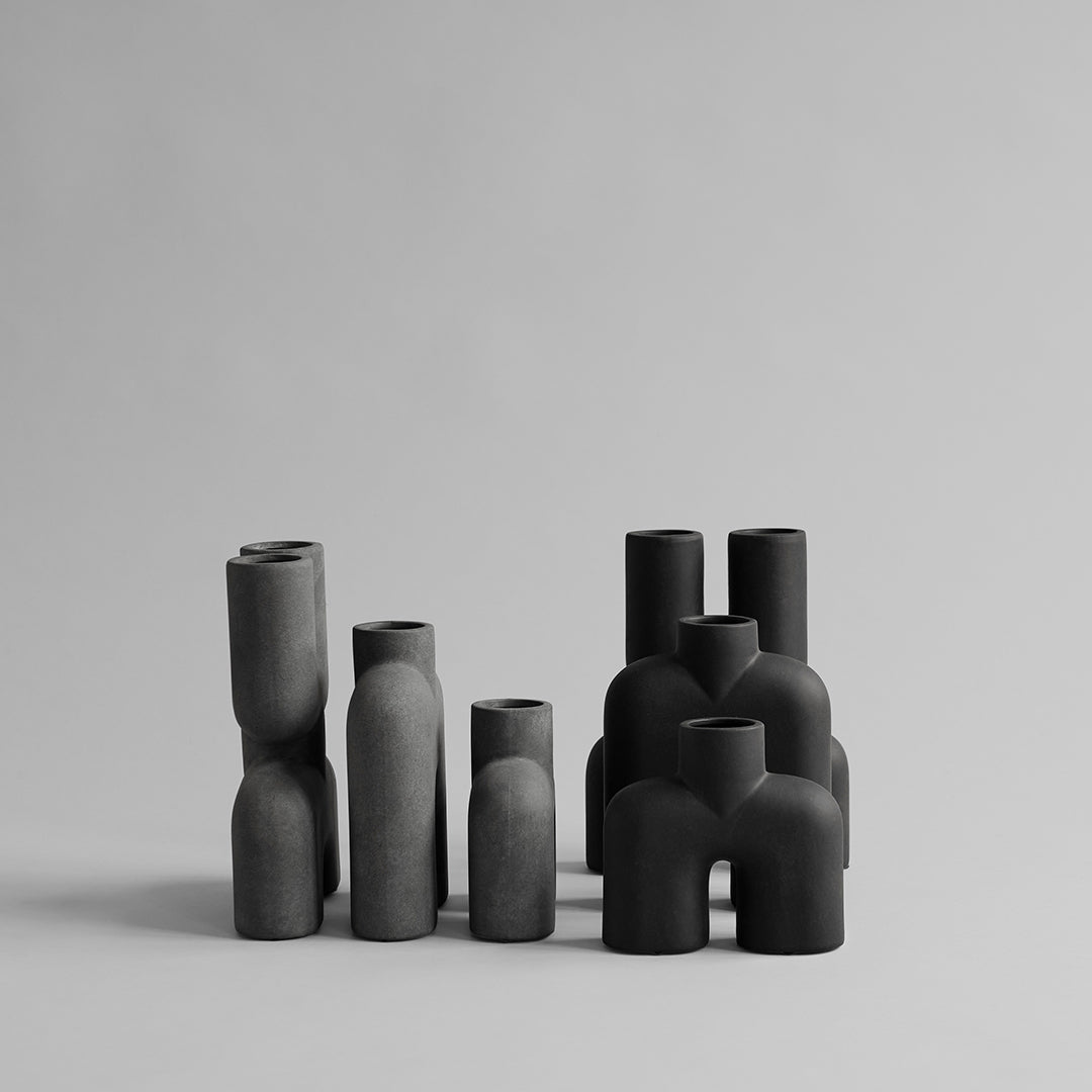Set of matte black vases in various shapes and sizes, featuring smooth and textured finishes.