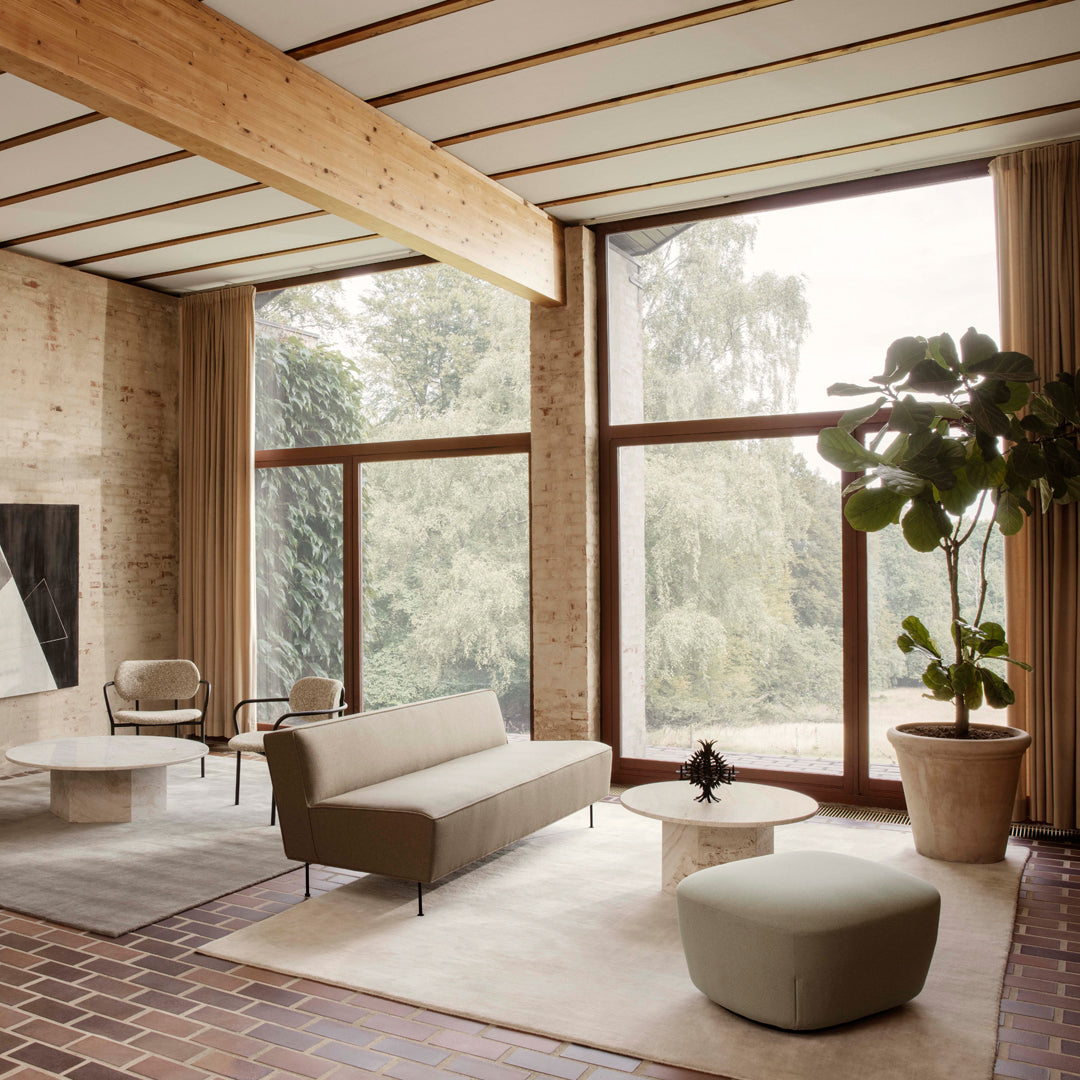 "Modern living room featuring neutral tones, soft textures, and natural wood accents, complemented by greenery."