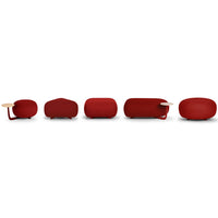 Five modern coffee tables in varying shades of deep red with smooth, rounded shapes and natural wood accents.