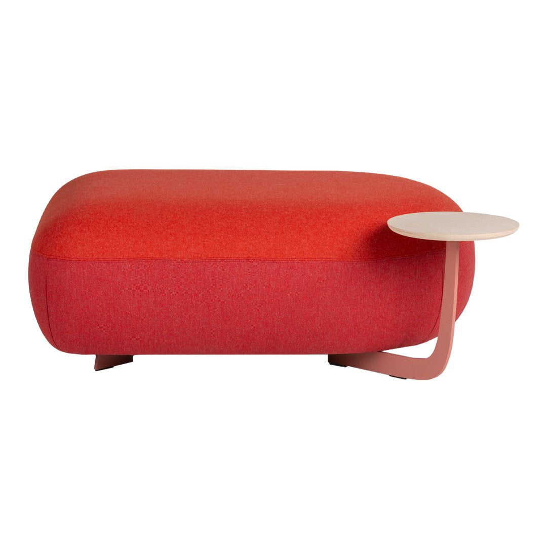 Red upholstered ottoman with a sleek, minimalist design and a curved side table in soft beige tones.