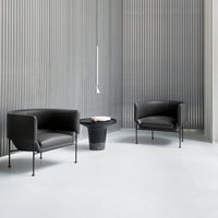"Modern black leather chairs against a textured gray wall, featuring smooth lines and minimalistic design."