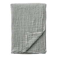 Soft grey muslin blanket with a textured, wrinkled pattern, perfect for cozy spaces and stylish décor.