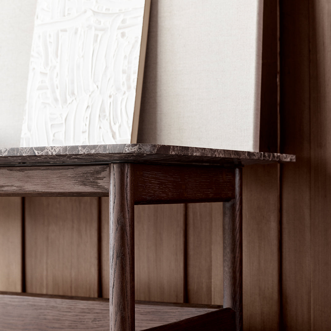 Neutral-toned canvas art on a wooden shelf, featuring textured white patterns against a warm wood backdrop.