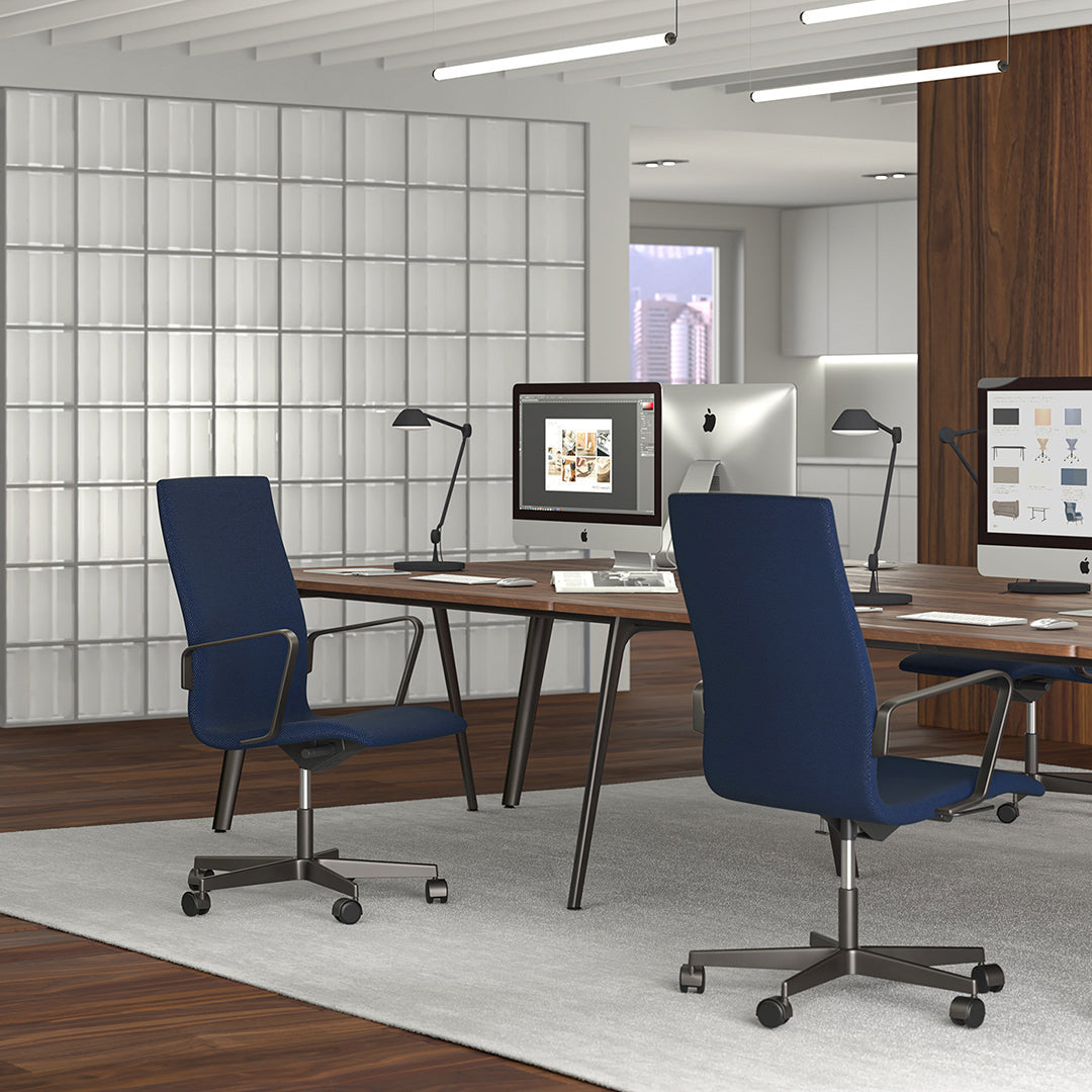 "Two sleek navy blue office chairs on a wood floor, complemented by a modern white rug and light grey walls."