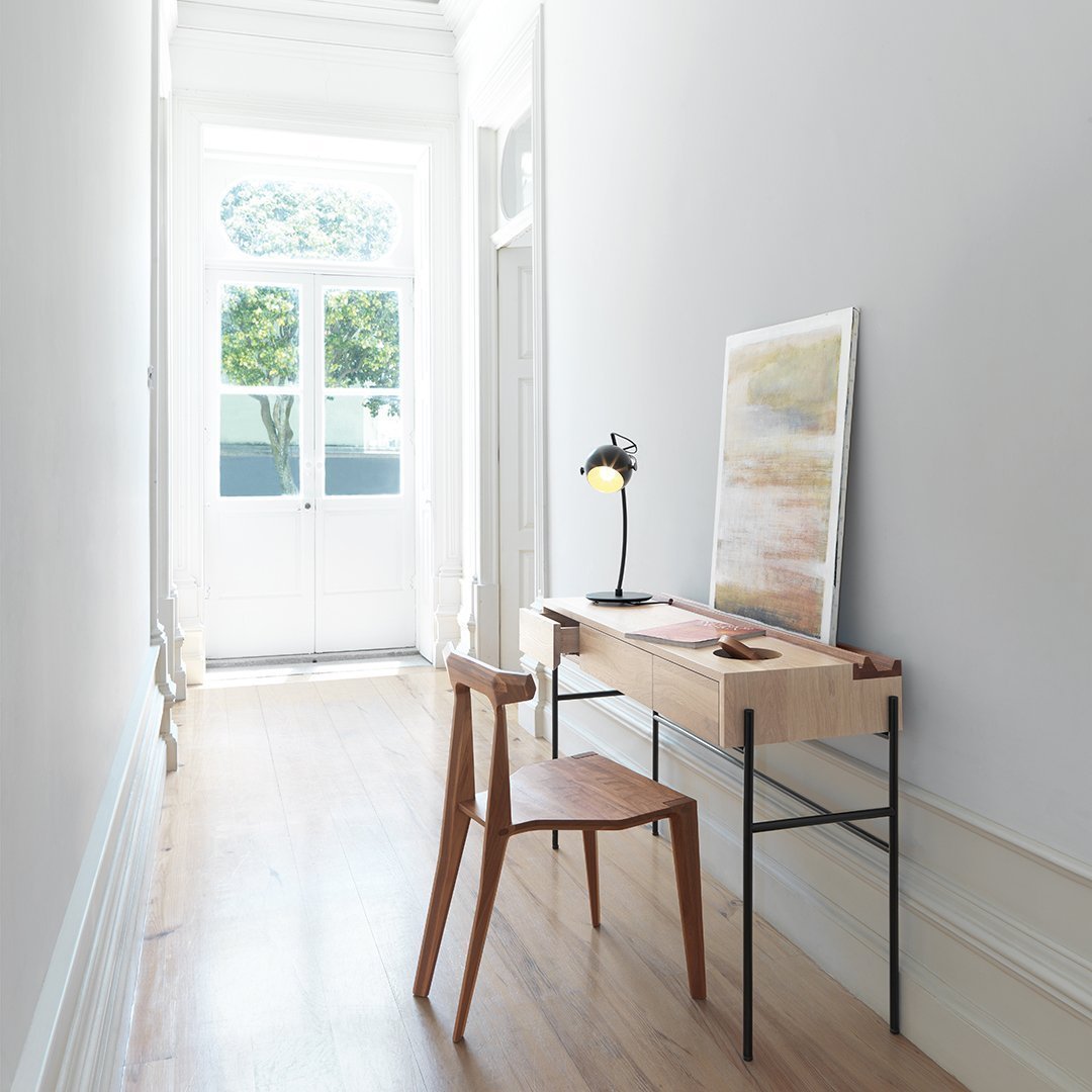 Scandi-style wooden desk and chair in neutral tones with a minimalist pattern, complementing a bright, airy hallway.