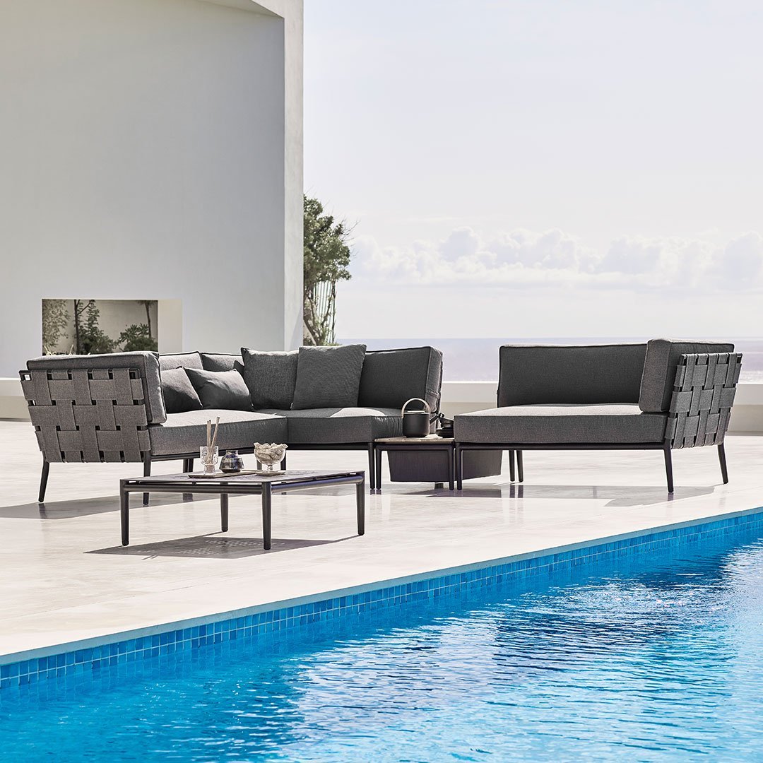 Stylish gray outdoor sofa set with sleek black accents and geometric pattern, perfect for patio or poolside settings.