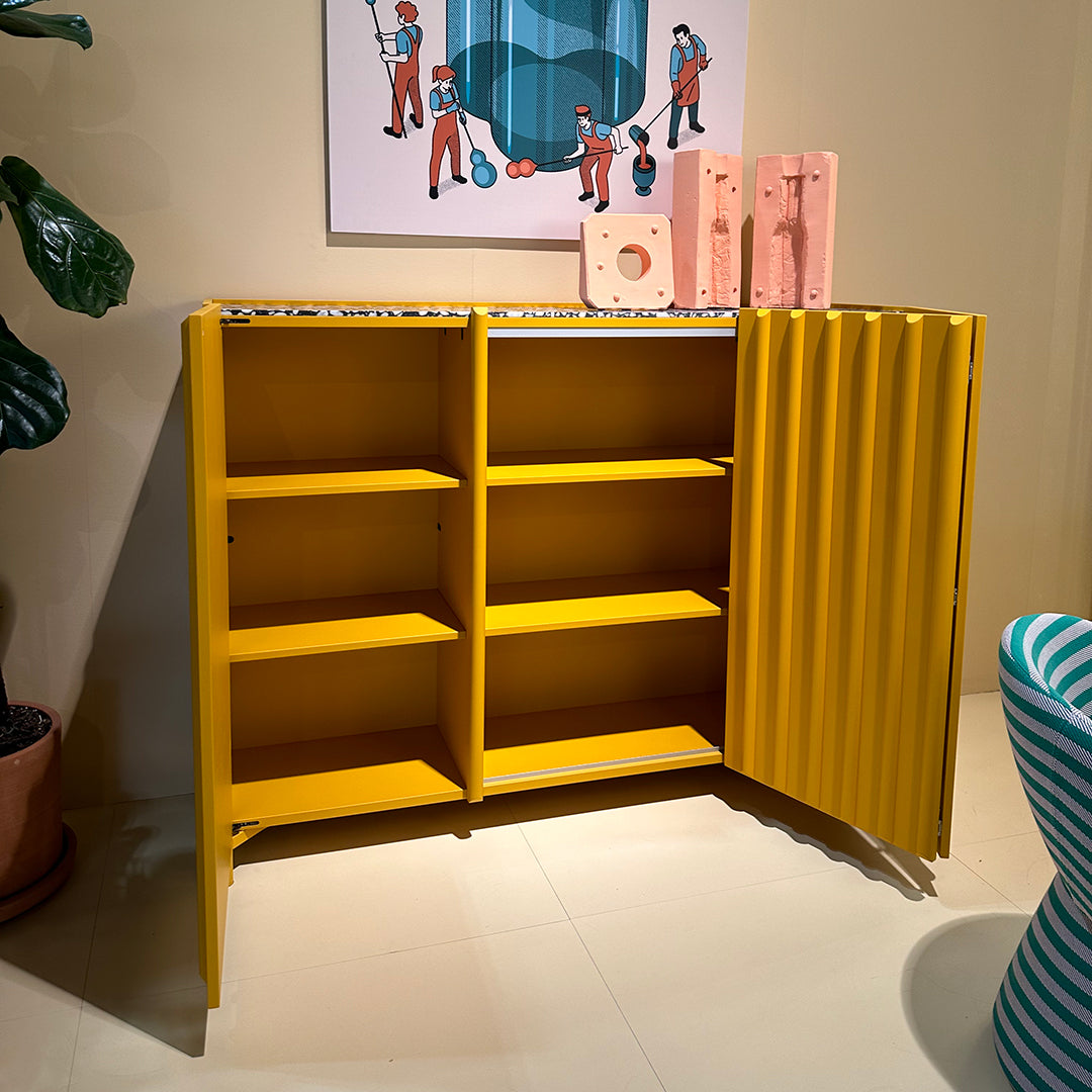 Bright yellow cabinet with ribbed texture and vibrant patterns, featuring multiple open shelves and colorful accents.