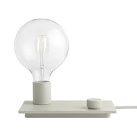 Elegant white lamp with a clear glass bulb, featuring a minimalist design and soft, neutral tones. Perfect for modern decor.