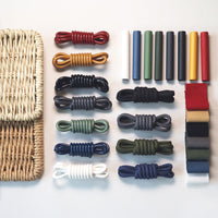 Assorted colorful cords in earthy tones, including red, yellow, green, navy, and white, with woven basket.