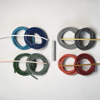 Colorful coils of wire in blue, green, gray, red, and orange, arranged neatly on a white background.